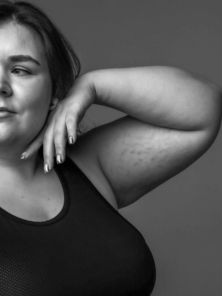 A curvy model photographed at eye level, cropped at the chest.